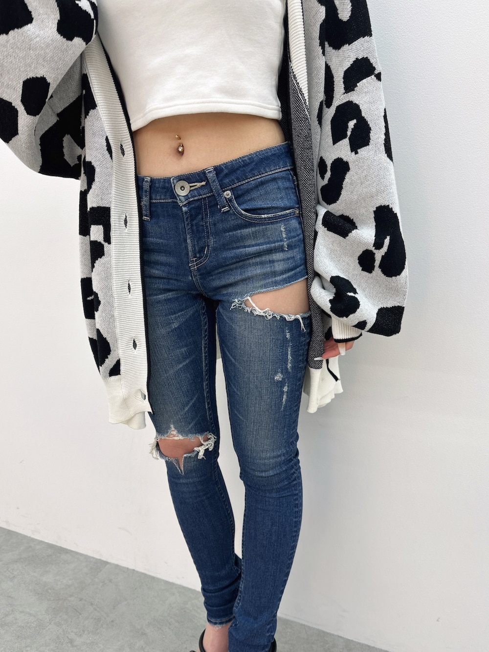 ブルー系のデニムパンツ、ブラック系のサンダル、ホワイト系のカーディガン/ボレロを着用したレディースの夏コーディネートの6枚目の写真