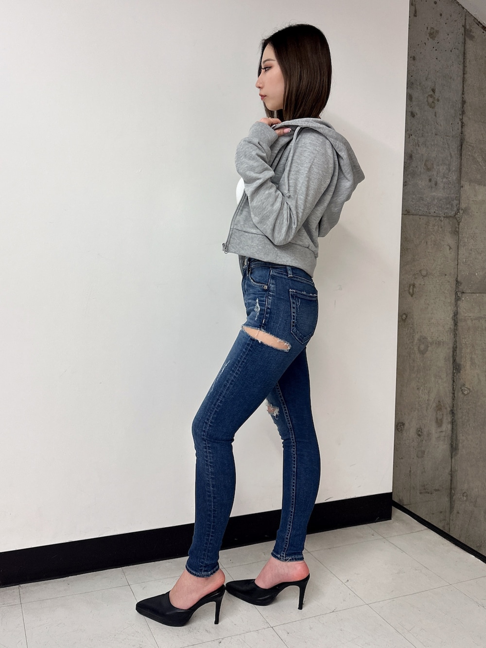 ホワイト系のキャミソール、グレー系のパーカー、ブラック系のパンプスを着用したレディースの春コーディネートの2枚目の写真
