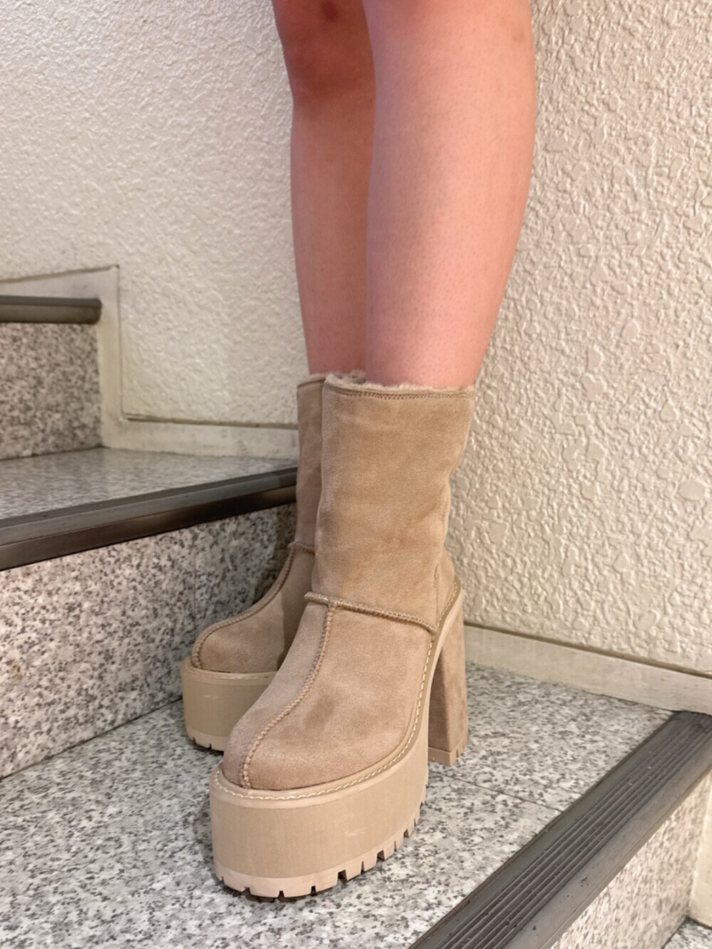 ブラック系のデニムスカート、ベージュ系のブーツ、グレー系のニット/セーターを着用したレディースの秋コーディネートの5枚目の写真