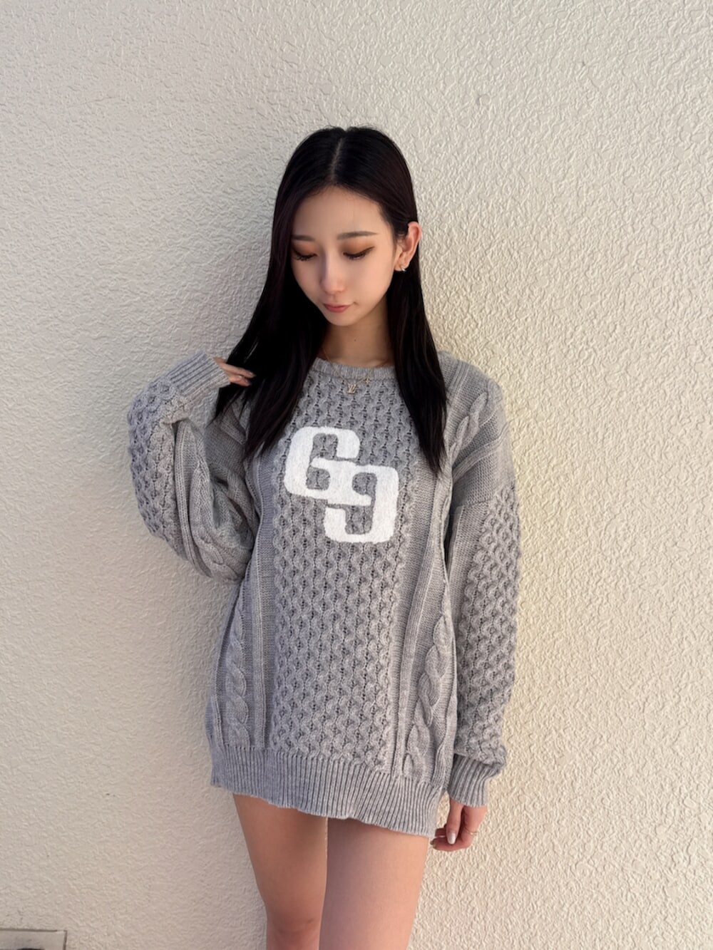 ブラック系のデニムスカート、ベージュ系のブーツ、グレー系のニット/セーターを着用したレディースの秋コーディネートの4枚目の写真