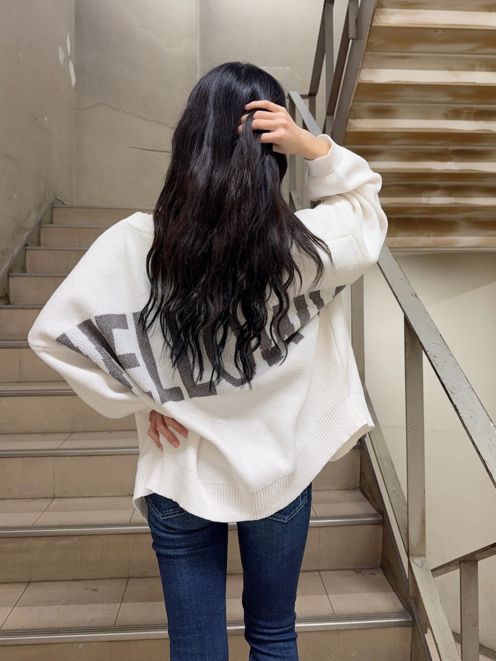 ブルー系のデニムパンツ、ブラック系のキャミソール、ホワイト系のカーディガン/ボレロを着用したレディースの冬コーディネートの3枚目の写真