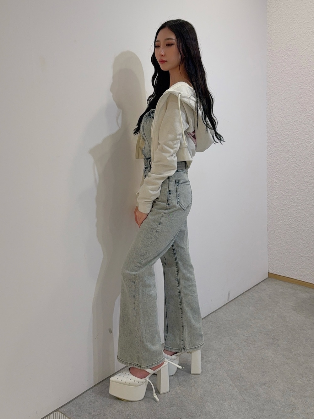 ブルー系のつなぎ/オールインワン、ホワイト系のパーカー、ホワイト系のパンプスを着用したレディースの冬コーディネートの2枚目の写真