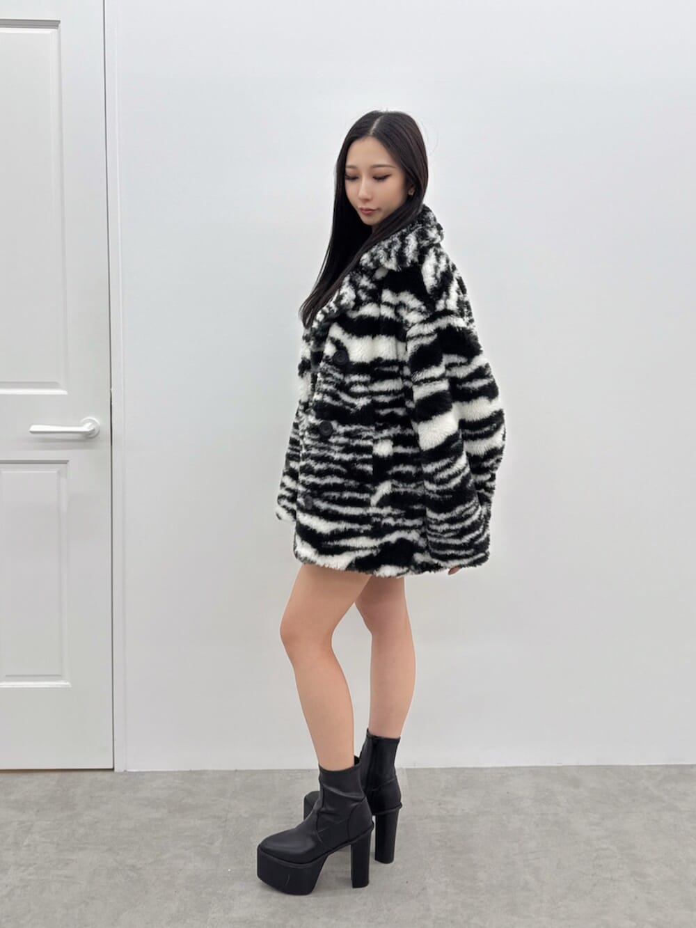 ブラック系のブーツ、ブラック系のデニムスカート、その他のブルゾンを着用したレディースの秋コーディネートの2枚目の写真