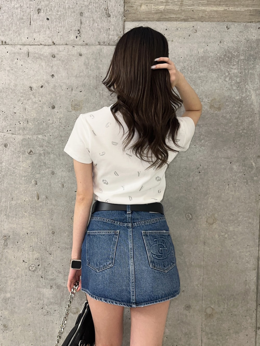 ブルー系のデニムスカート、ホワイト系のTシャツ/カットソー、ブラック系のサンダルを着用したレディースの春コーディネートの5枚目の写真