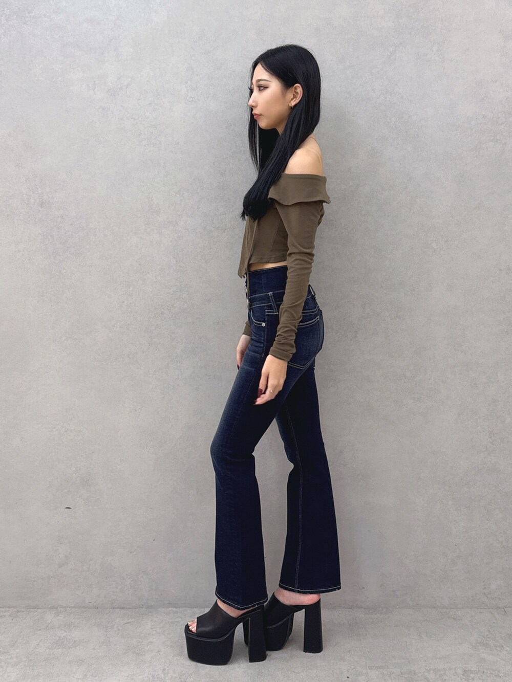 ブルー系のデニムパンツ、グリーン系のTシャツ/カットソー、ブラック系のサンダルを着用したレディースの夏コーディネートの2枚目の写真