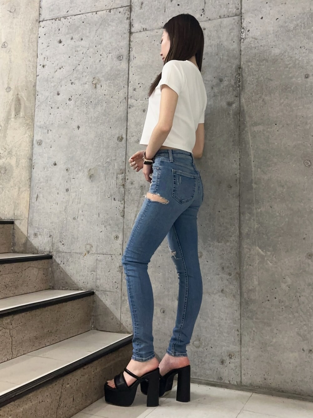 ブラック系のサンダル、ブルー系のデニムパンツ、ホワイト系のTシャツ/カットソーを着用したレディースの春コーディネートの2枚目の写真