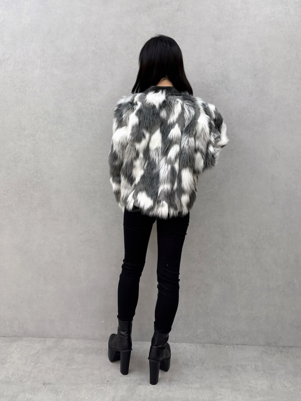 ブラック系のデニムパンツ、ブラック系のブーツ、ホワイト系のニット/セーターを着用したレディースの秋コーディネートの3枚目の写真