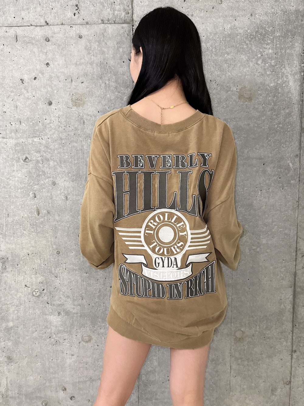 イエロー系のスウェット、ブラック系のブーツ、ブラック系のデニムスカートを着用したレディースの夏コーディネートの6枚目の写真