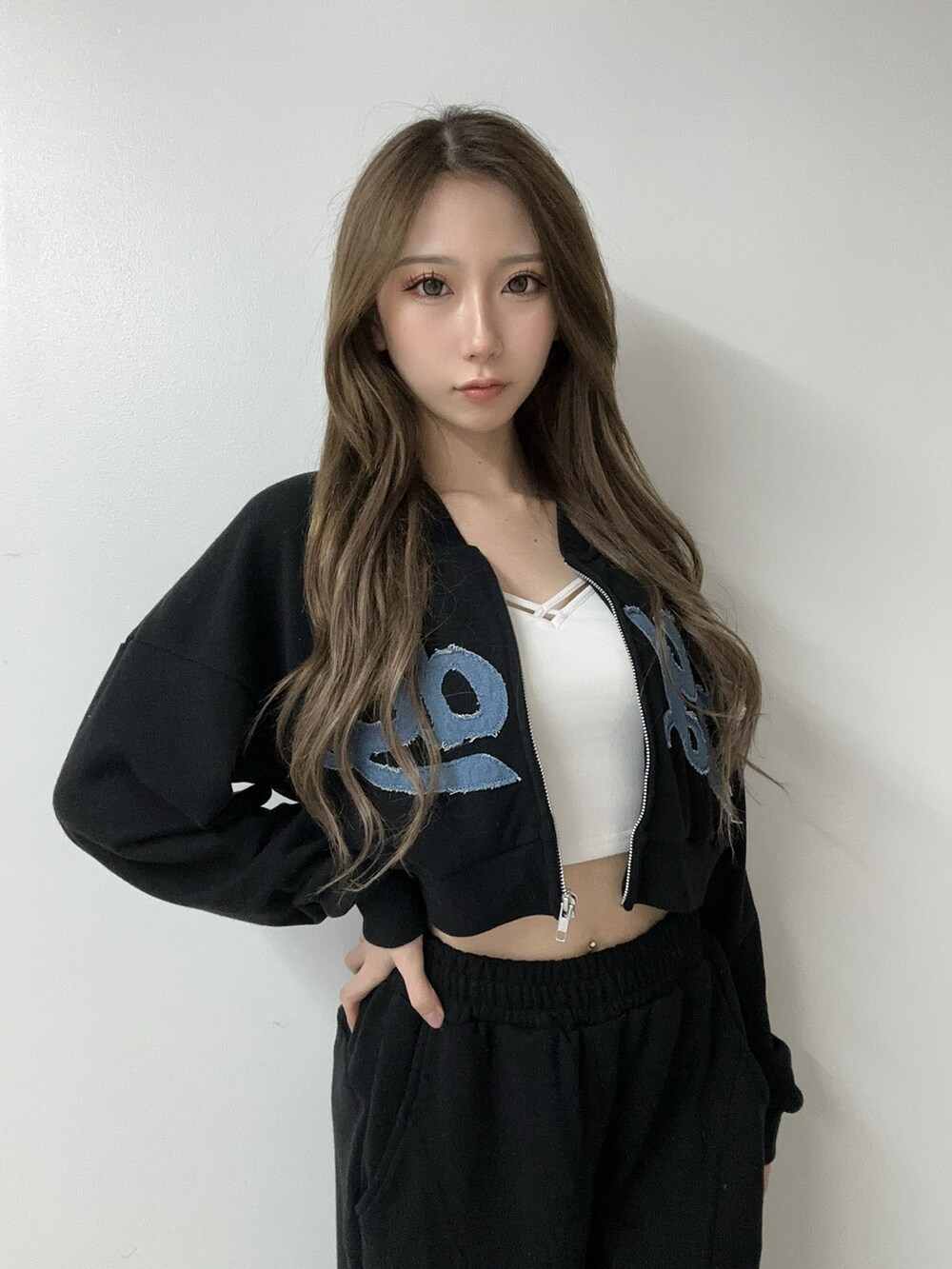 ブラック系のパンプス、ブラック系のスウェット、ホワイト系のキャミソールを着用したレディースの冬コーディネートの4枚目の写真