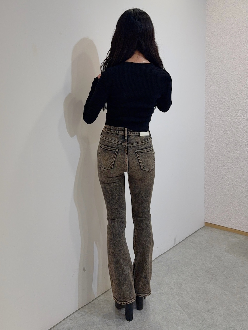 ブルー系のデニムパンツ、ブラック系のニット/セーター、ブラック系のブーツを着用したレディースの冬コーディネートの3枚目の写真