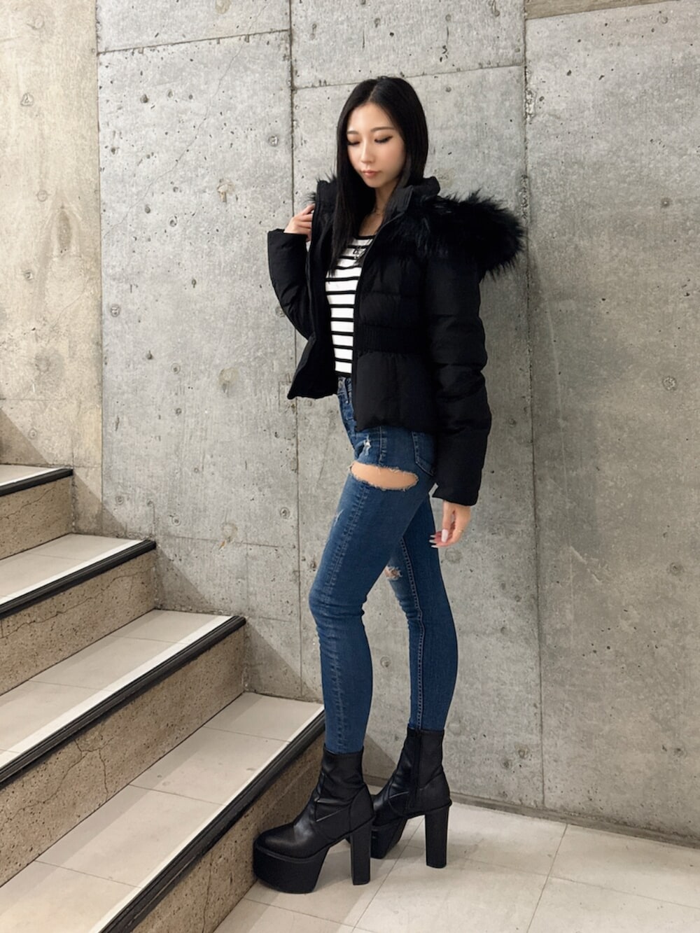 ブラック系のブーツ、その他のニット/セーター、ブルー系のデニムパンツを着用したレディースの秋コーディネートの2枚目の写真