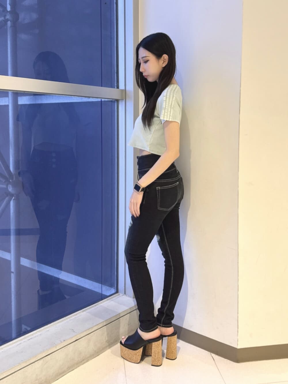ブルー系のデニムパンツ、ブラック系のサンダル、ブルー系のTシャツ/カットソーを着用したレディースの夏コーディネートの2枚目の写真