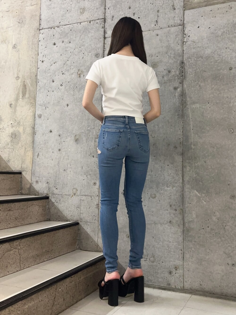 ブラック系のサンダル、ブルー系のデニムパンツ、ホワイト系のTシャツ/カットソーを着用したレディースの春コーディネートの3枚目の写真