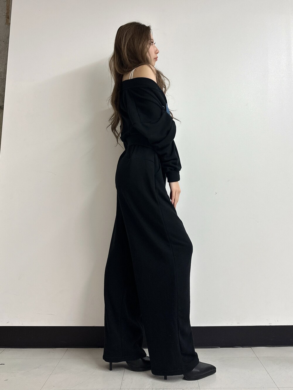 ブラック系のパンプス、ブラック系のスウェット、ホワイト系のキャミソールを着用したレディースの冬コーディネートの2枚目の写真