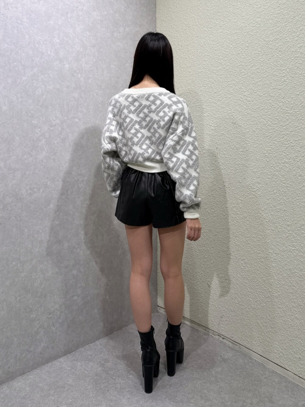 ブラック系のブーツ、ブラック系のその他パンツ、ホワイト系のニット/セーターを着用したレディースの秋コーディネートの3枚目の写真