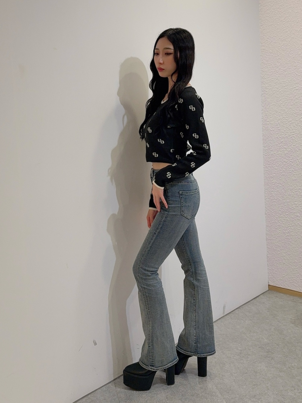 ブルー系のデニムパンツ、ブラック系のニット/セーター、ブラック系のブーツを着用したレディースの冬コーディネートの2枚目の写真