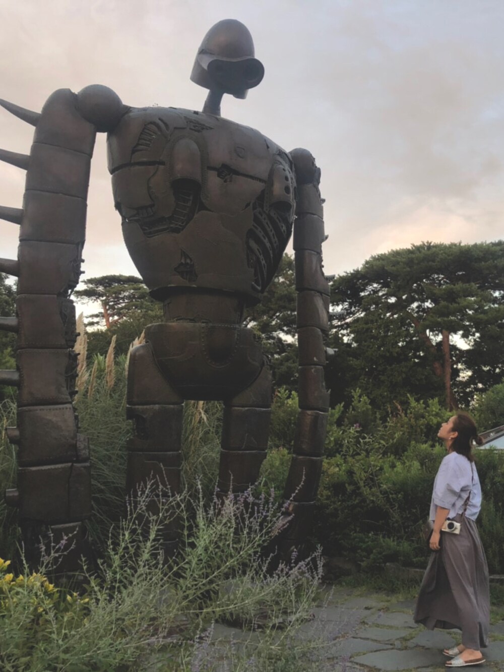 ブルー系のシャツ/ブラウス、グレー系のスカート、シルバー系のサンダルを着用したレディースの夏コーディネートの2枚目の写真