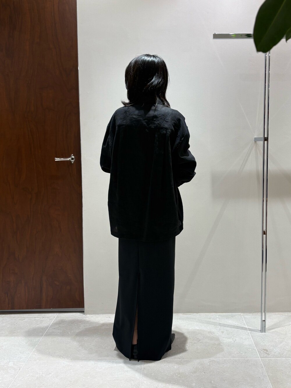 ブラック系のベスト、ブラック系のスカート、ブラック系のスリッポンを着用したレディースの春コーディネートの3枚目の写真