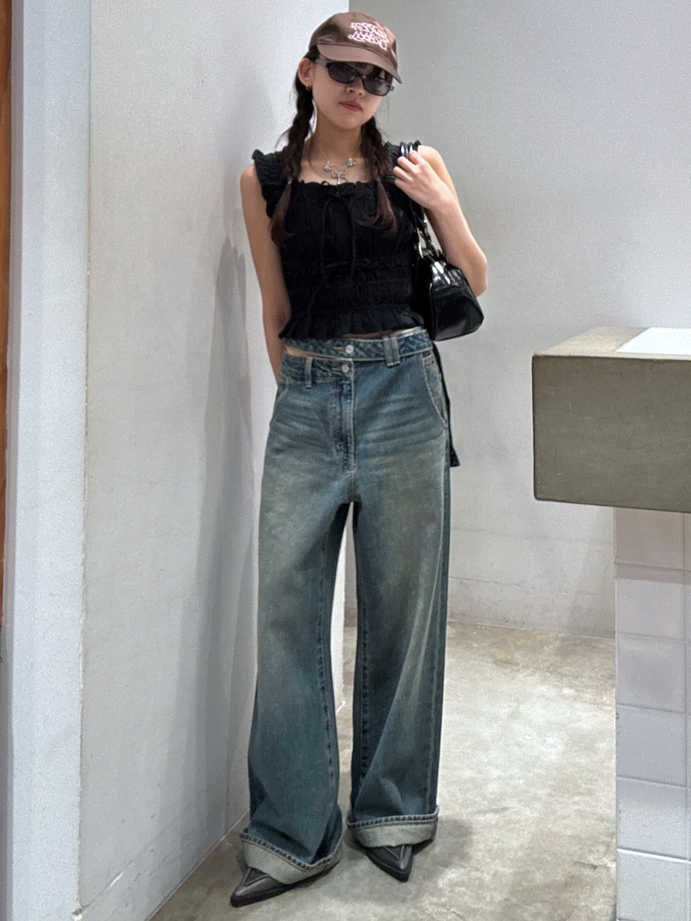 ブラック系のシャツ/ブラウス、ブルー系のデニムパンツ、ブラック系のパンプスを着用したレディースの夏コーディネートの2枚目の写真