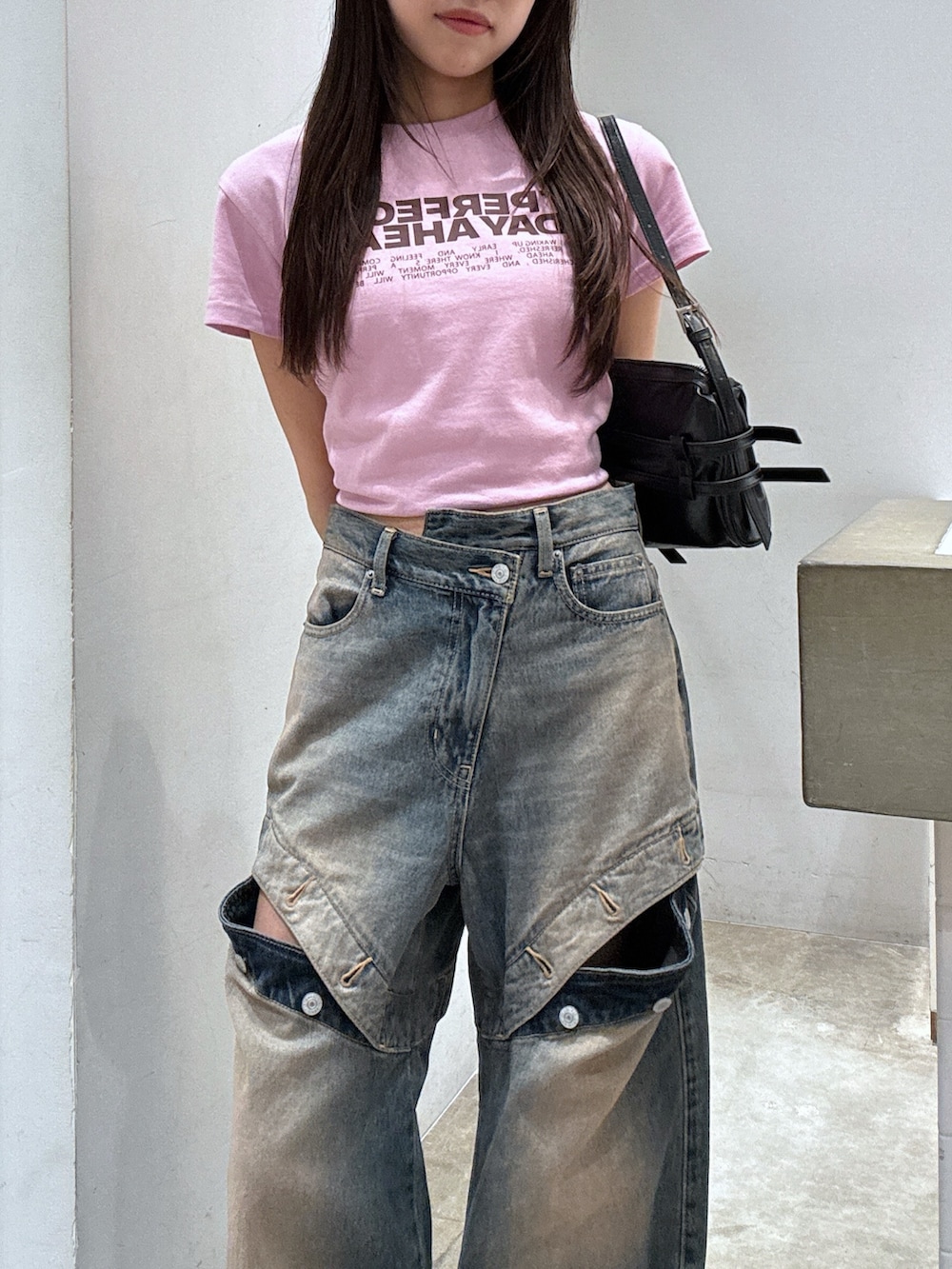 ピンク系のTシャツ/カットソー、ブラック系のショルダーバッグ、ブルー系のデニムパンツを着用したレディースの夏コーディネートの2枚目の写真