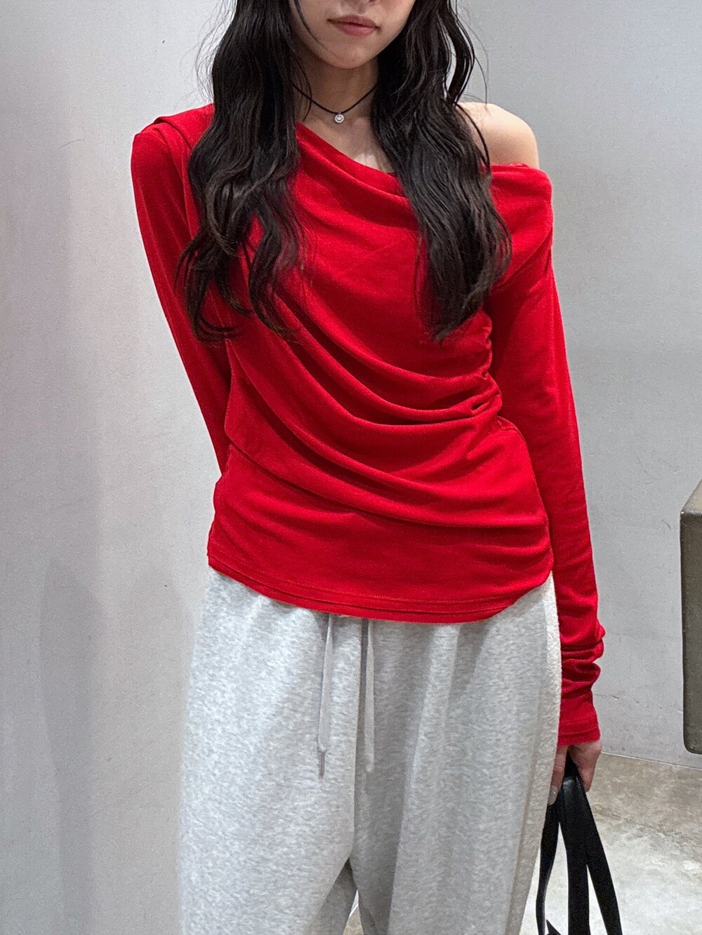 グレー系のスウェットパンツ、レッド系のTシャツ/カットソー、ブラック系のショルダーバッグを着用したレディースの秋コーディネートの2枚目の写真