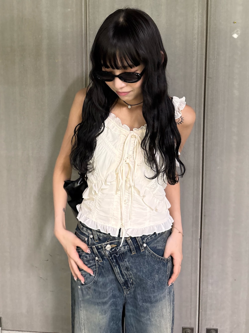 ブルー系のデニムパンツ、ベージュ系のローファー、ホワイト系のキャミソールを着用したレディースの夏コーディネートの3枚目の写真