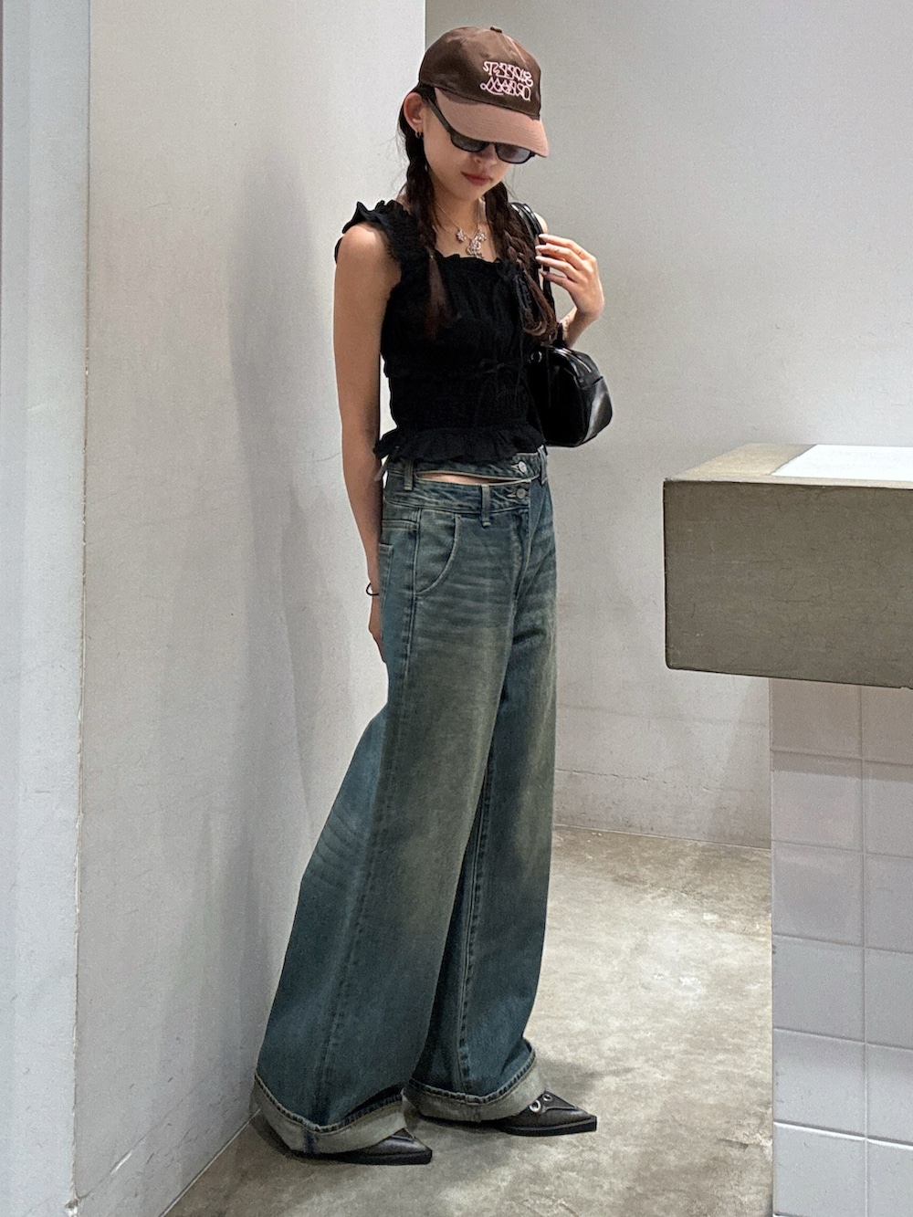 ブラック系のシャツ/ブラウス、ブルー系のデニムパンツ、ブラック系のパンプスを着用したレディースの夏コーディネートの3枚目の写真