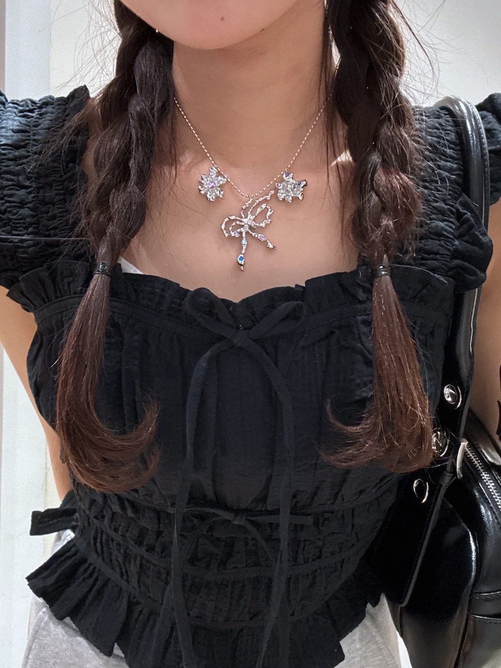 ブラック系のシャツ/ブラウス、ブルー系のデニムパンツ、ブラック系のパンプスを着用したレディースの夏コーディネートの4枚目の写真