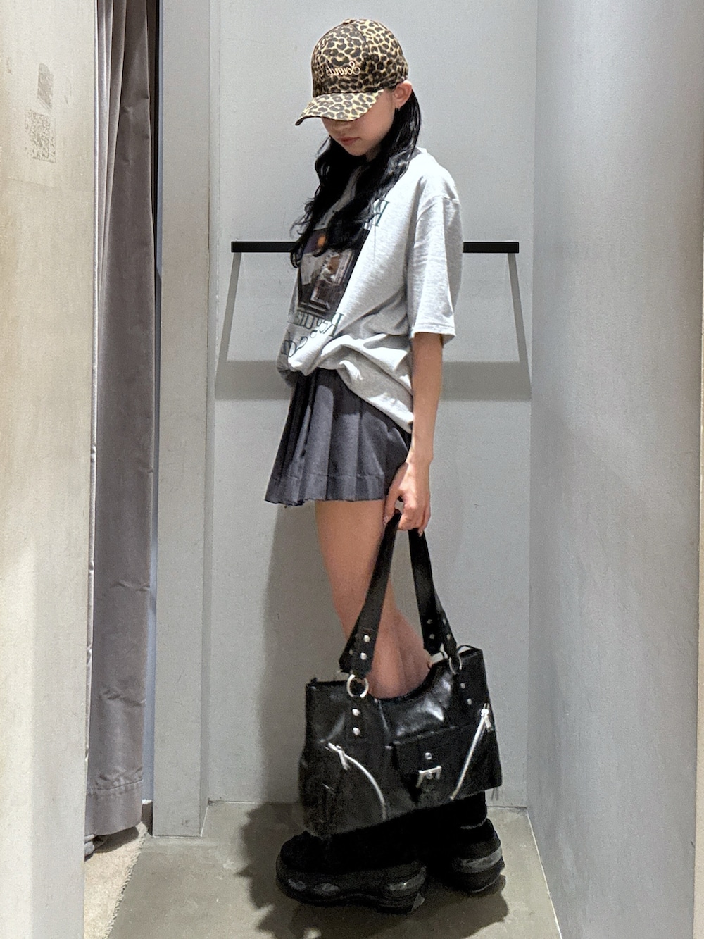 グレー系のTシャツ/カットソー、グレー系のスカート、ブラック系のショルダーバッグを着用したレディースの夏コーディネートの2枚目の写真