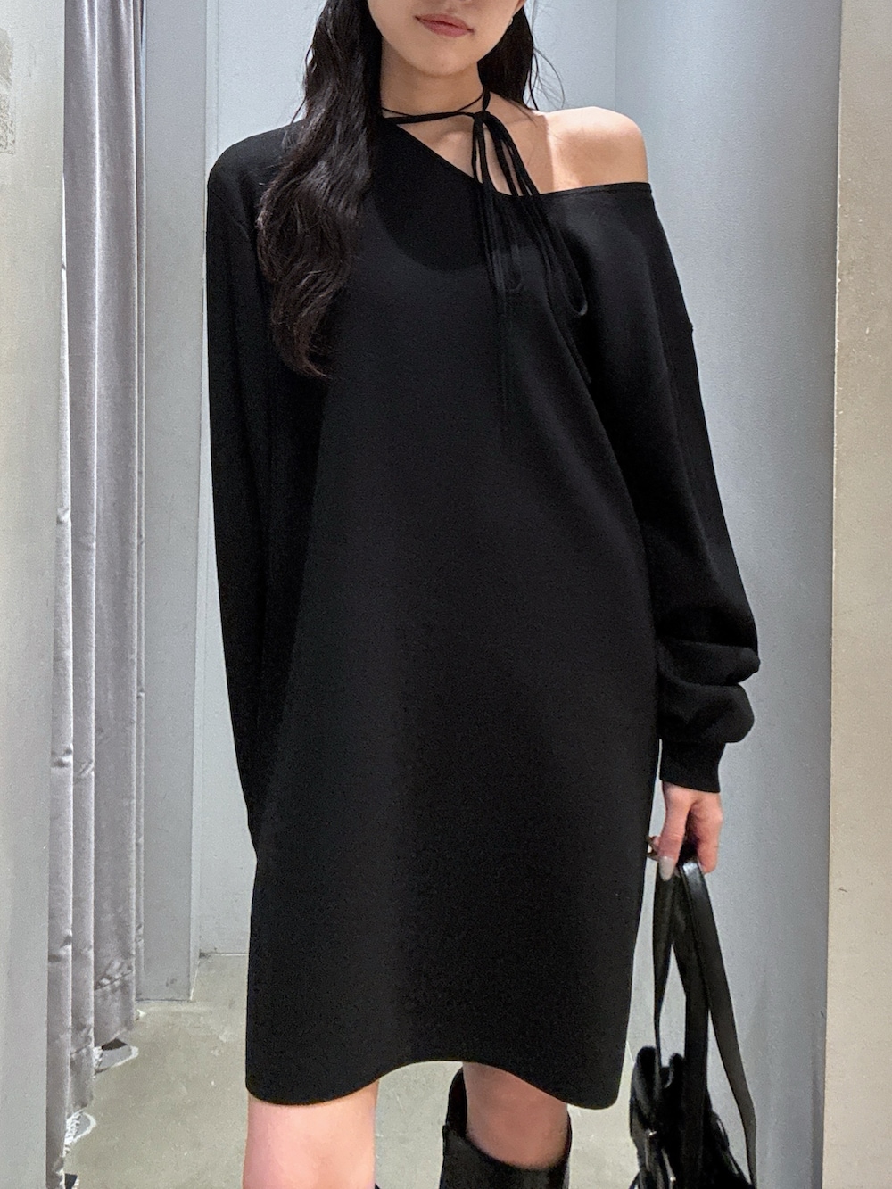 ブラック系のワンピース、ブラック系のブーツ、ブラック系のショルダーバッグを着用したレディースの秋コーディネートの2枚目の写真