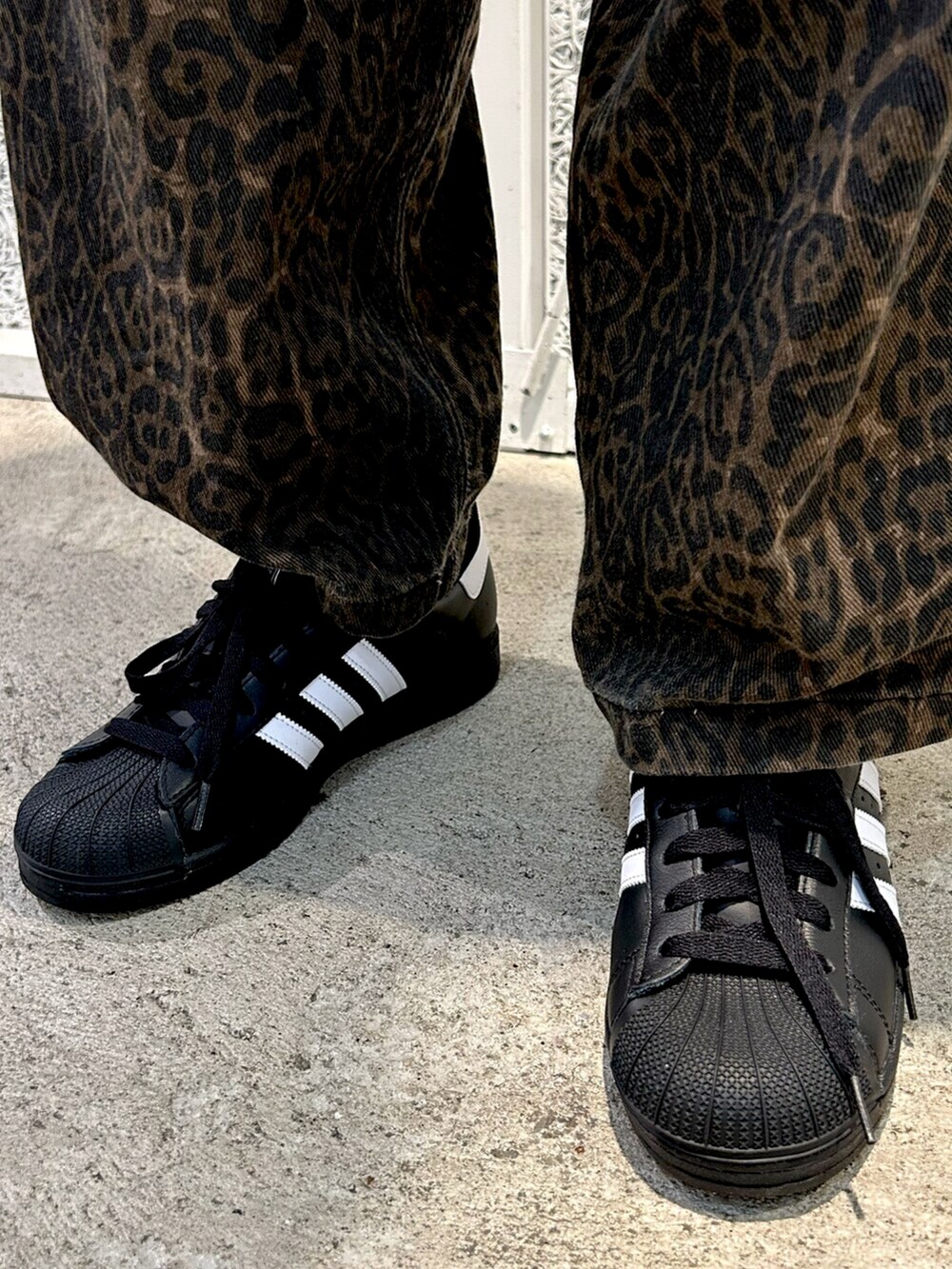 ブラック系のジャージ、ブラック系のスニーカーを着用したメンズの夏コーディネートの2枚目の写真