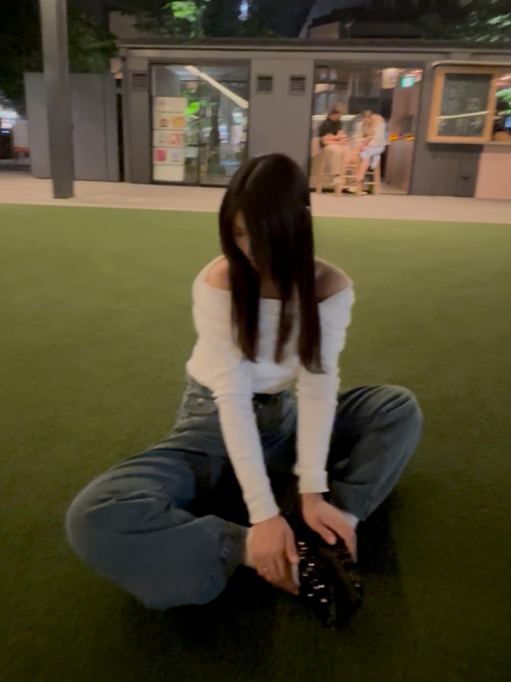 ホワイト系のニット/セーター、ブルー系のデニムパンツ、ブラック系のバレエシューズを着用したレディースの春コーディネートの2枚目の写真