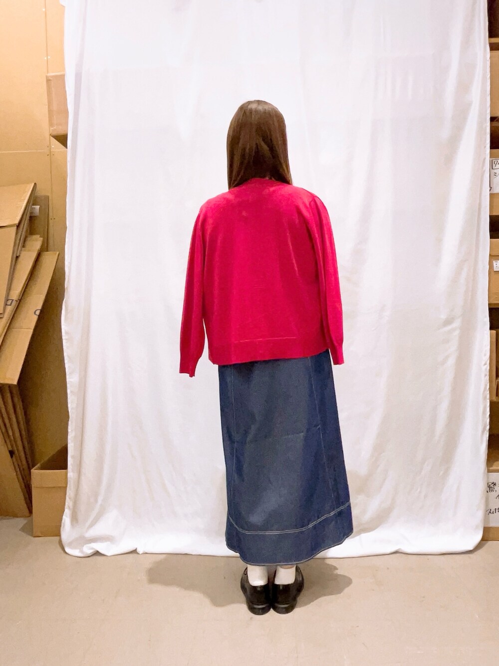 レッド系のカーディガン/ボレロ、ブルー系のワンピース、ベージュ系のショルダーバッグを着用したレディースの秋コーディネートの2枚目の写真