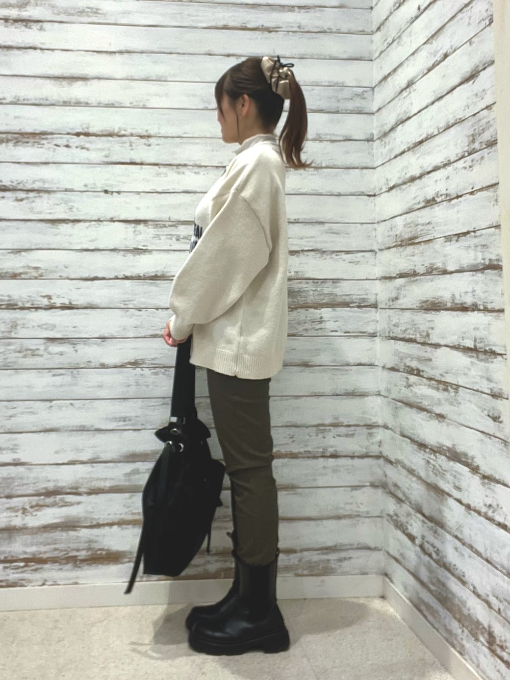 ホワイト系のニット/セーター、グリーン系のその他パンツ、ブラック系のショルダーバッグを着用したレディースの冬コーディネートの3枚目の写真