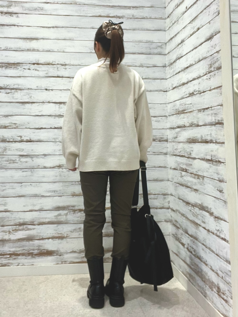 ホワイト系のニット/セーター、グリーン系のその他パンツ、ブラック系のショルダーバッグを着用したレディースの冬コーディネートの2枚目の写真