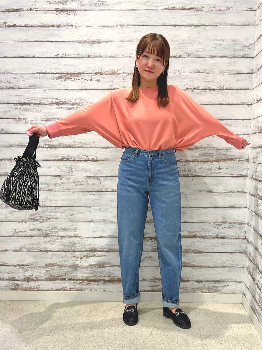 ピンク系のシャツ/ブラウス、ブルー系のデニムパンツ、ブラック系のトートバッグを着用したレディースの春コーディネートの4枚目の写真