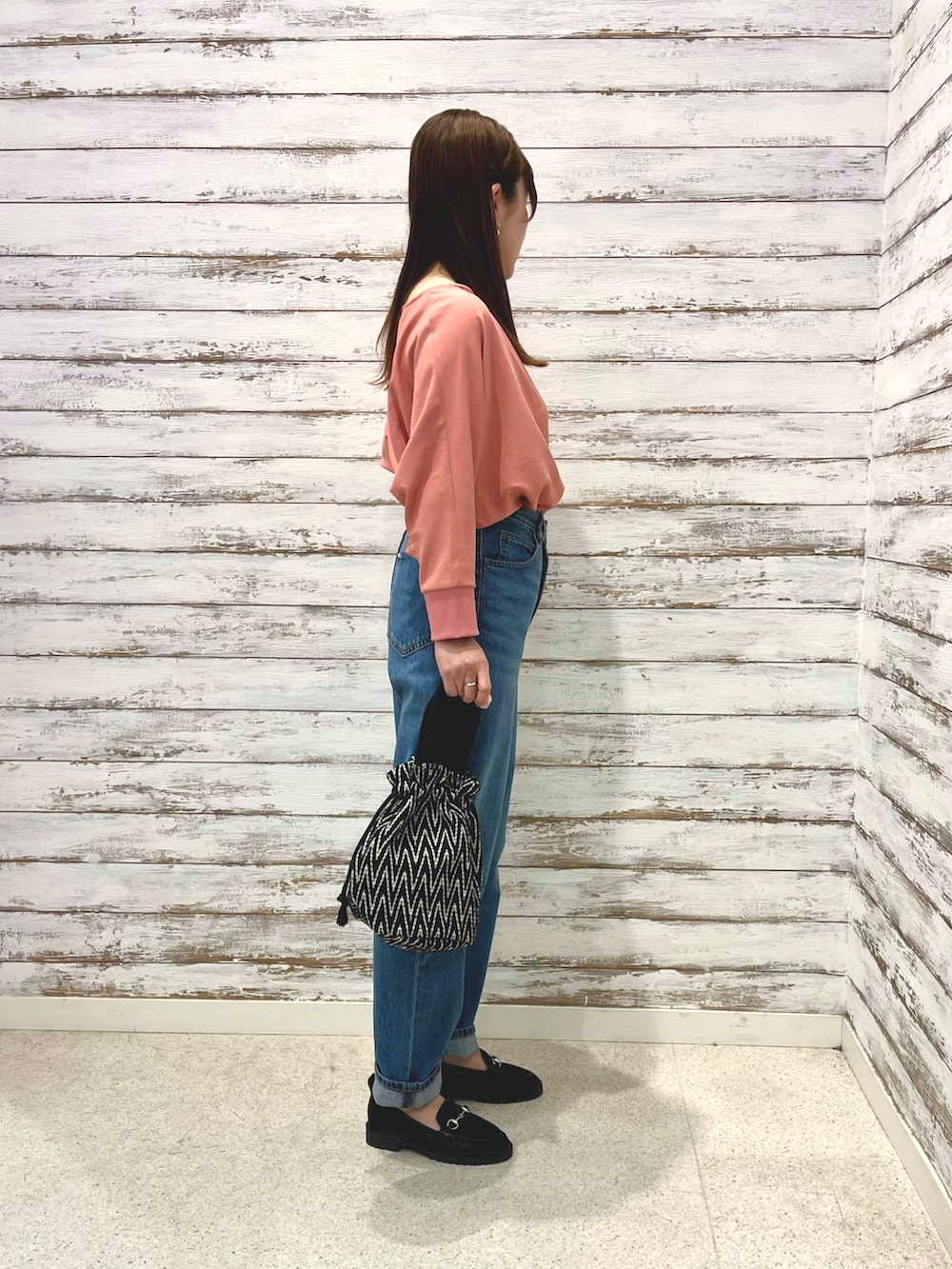 ピンク系のシャツ/ブラウス、ブルー系のデニムパンツ、ブラック系のトートバッグを着用したレディースの春コーディネートの2枚目の写真