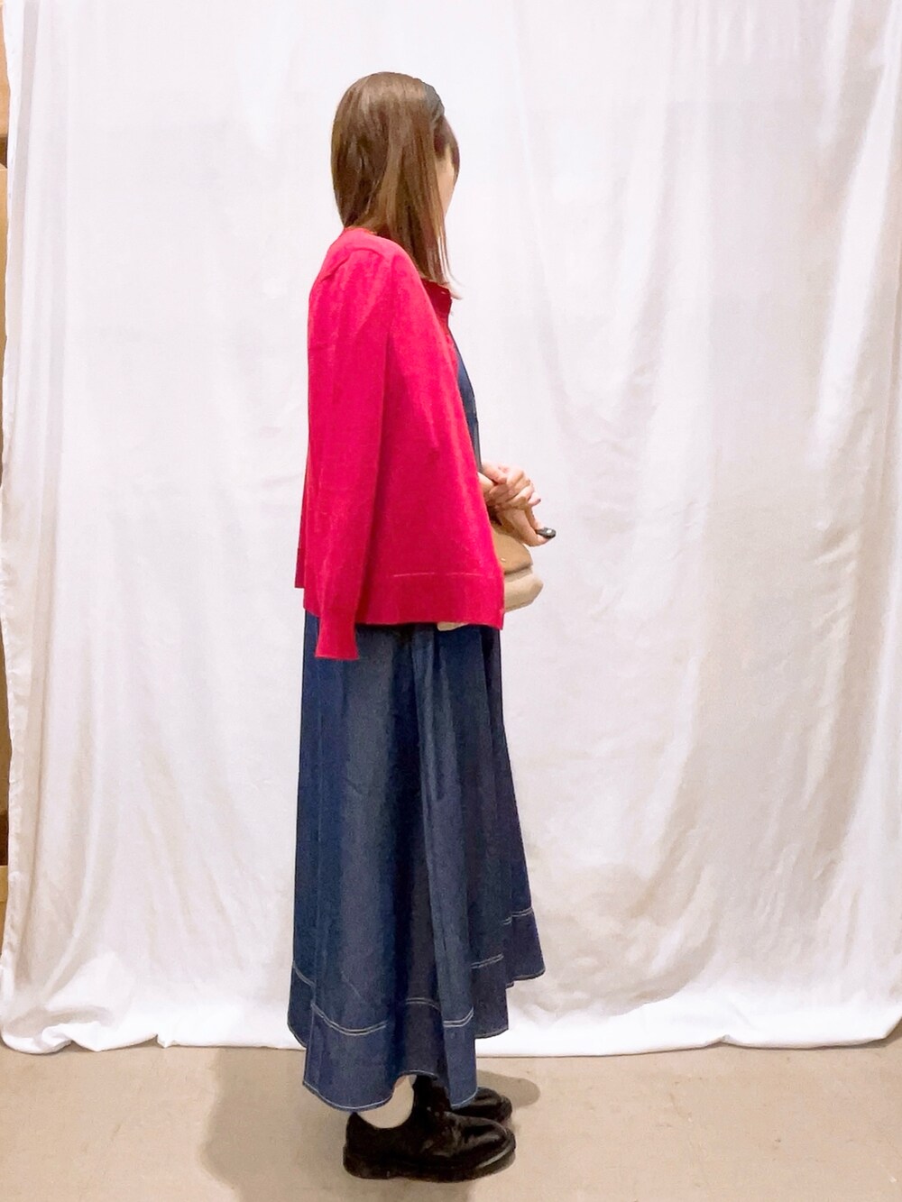 レッド系のカーディガン/ボレロ、ブルー系のワンピース、ベージュ系のショルダーバッグを着用したレディースの秋コーディネートの3枚目の写真