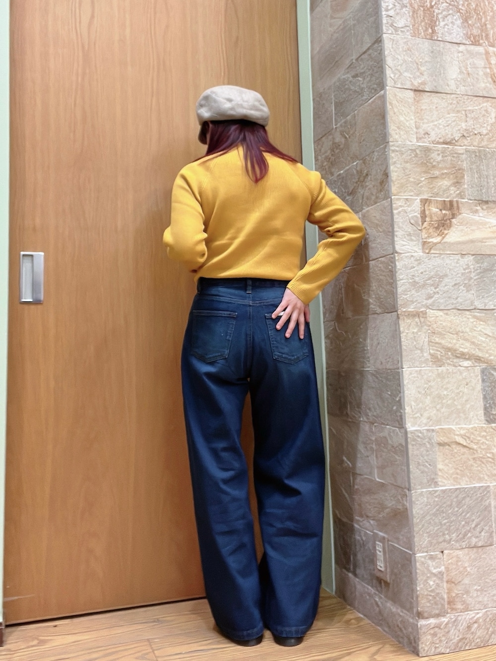 イエロー系のニット/セーター、ブルー系のデニムパンツを着用したレディースの秋コーディネートの2枚目の写真