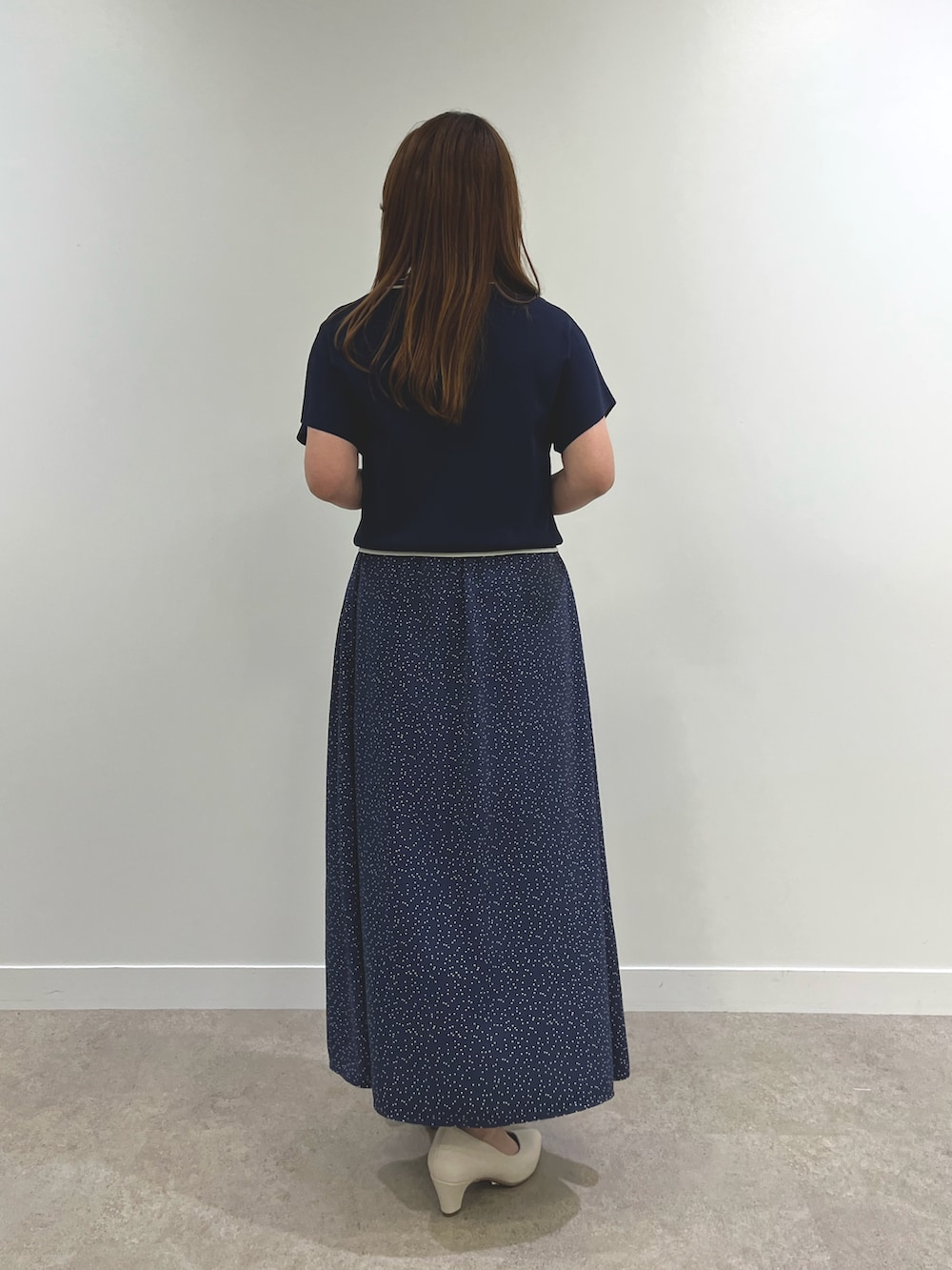 ホワイト系のパンプス、ブルー系のニット/セーター、ブルー系のスカートを着用したレディースの春コーディネートの3枚目の写真