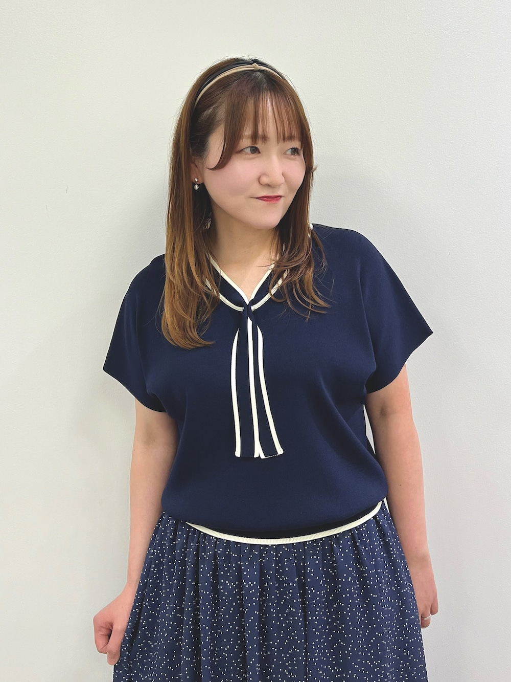 ホワイト系のパンプス、ブルー系のニット/セーター、ブルー系のスカートを着用したレディースの春コーディネートの2枚目の写真