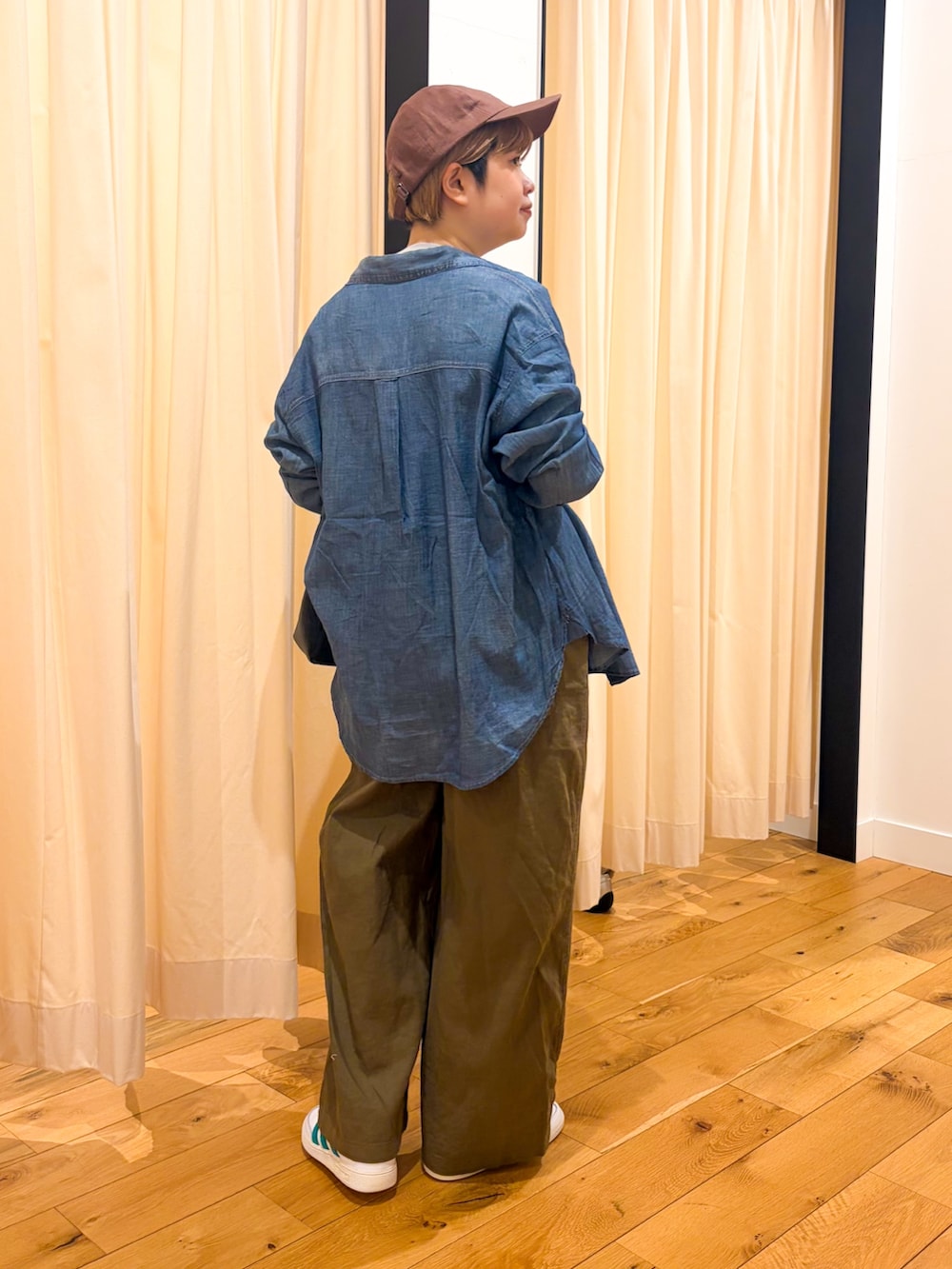 ホワイト系のスニーカー、グリーン系のサロペット/オーバーオール、ブラック系のショルダーバッグを着用したレディースの春コーディネートの4枚目の写真