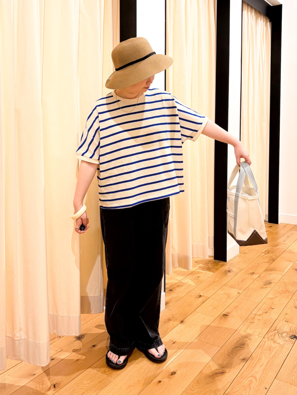 ブルー系のTシャツ/カットソー、グリーン系のトートバッグ、ブラック系のデニムパンツを着用したレディースの夏コーディネートの2枚目の写真