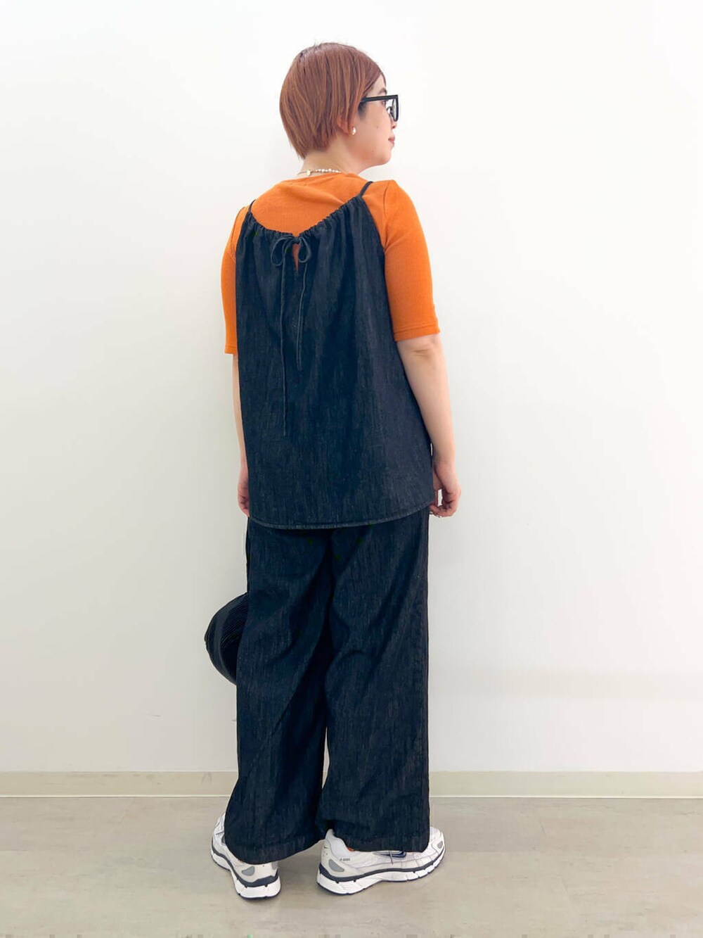 ブラック系のハンドバッグ、ブラック系のサロペット/オーバーオール、グレー系のTシャツ/カットソーを着用したレディースの秋コーディネートの4枚目の写真