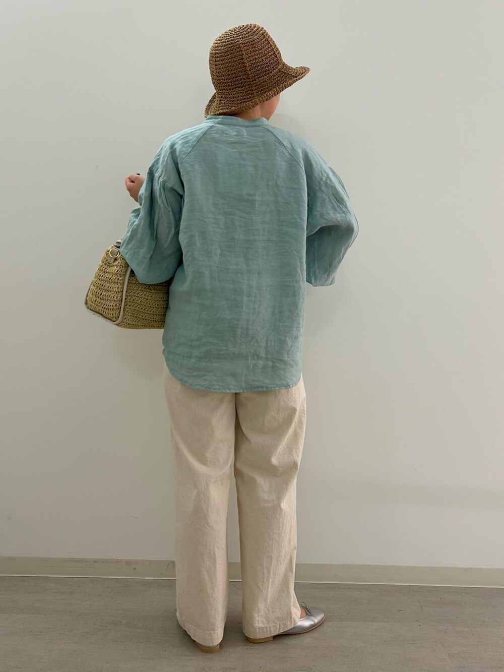 シルバー系のバレエシューズ、グリーン系のシャツ/ブラウス、ベージュ系のかごバッグを着用したレディースの春コーディネートの2枚目の写真