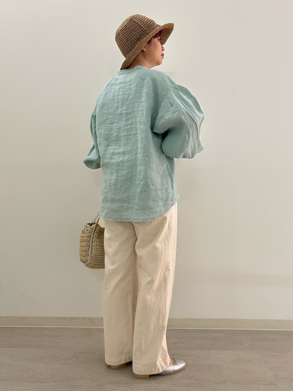 シルバー系のバレエシューズ、グリーン系のシャツ/ブラウス、ベージュ系のかごバッグを着用したレディースの春コーディネートの3枚目の写真