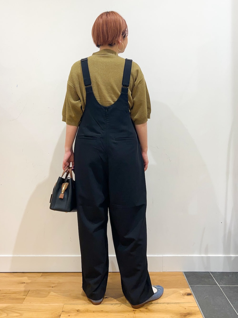 ブルー系のサロペット/オーバーオール、グリーン系のニット/セーター、ブラック系のハンドバッグを着用したレディースの夏コーディネートの2枚目の写真