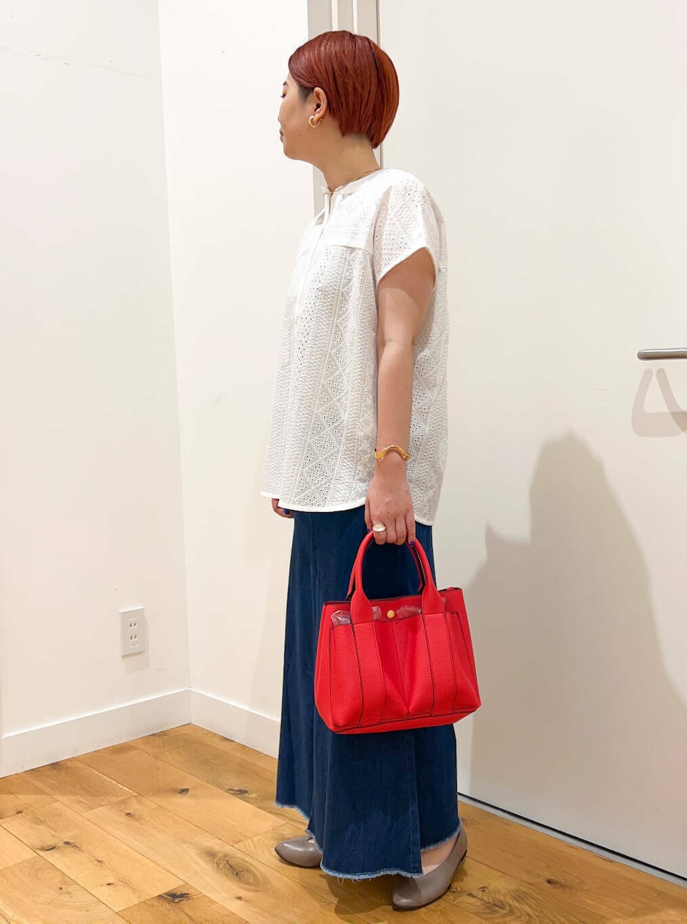 ホワイト系のシャツ/ブラウス、ベージュ系のパンプス、レッド系のトートバッグを着用したレディースの夏コーディネートの2枚目の写真