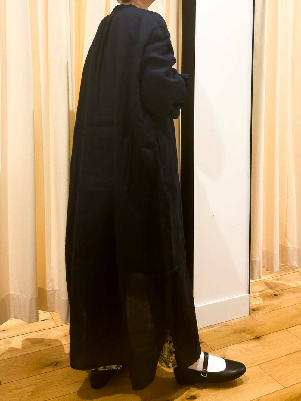 ブルー系のワンピース、ブラック系のパンプス、ベージュ系のトートバッグを着用したレディースの春コーディネートの5枚目の写真