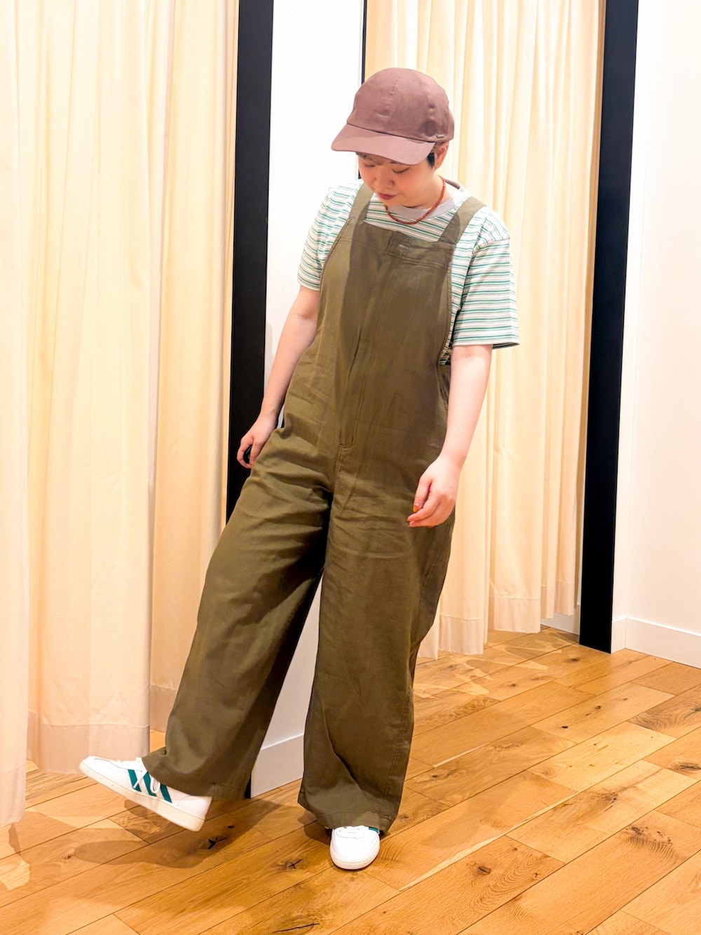 ホワイト系のスニーカー、グリーン系のサロペット/オーバーオール、ブラック系のショルダーバッグを着用したレディースの春コーディネートの2枚目の写真